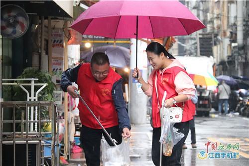 中國僑網(wǎng)黃申萍(左)冒雨撿拾垃圾(記者 羅建華攝)