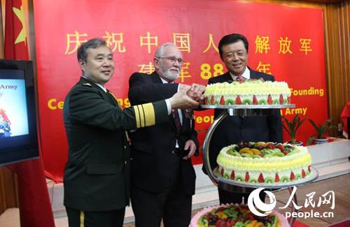 劉曉明大使(右一),、姚珉少將(左一)與英國諾曼底登陸老兵喬治·巴茨(中)一起切慶祝蛋糕。李應齊攝