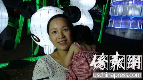 蔣女士抱著女兒在洛縣博覽會(huì)觀賞中秋花燈,。(美國(guó)《僑報(bào)》/高睿