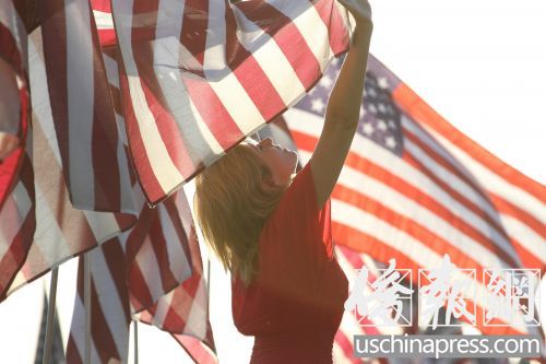 中國僑網(wǎng)旗海中的一名紅衣女子。(邱晨 攝)