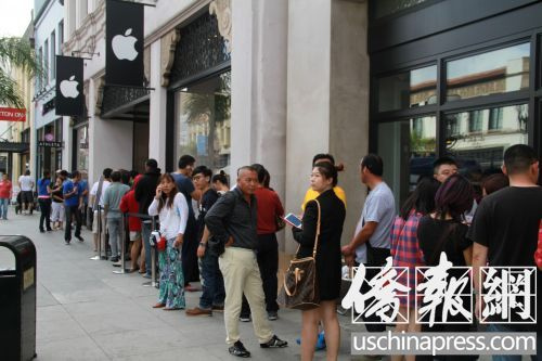 中國僑網(wǎng)搶購iPhone新款手機(jī)的“果粉”在蘋果手機(jī)專賣店前排長龍。(美國《僑報(bào)》/周慧一 攝)