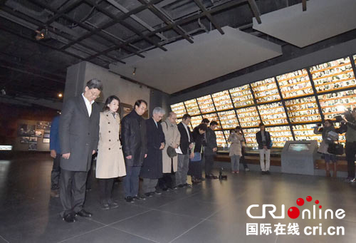 中國僑網(wǎng)海外華媒采訪團向南京大屠殺遇難同胞默哀。