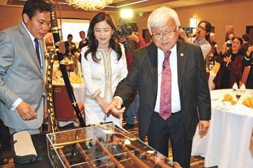 中國(guó)僑網(wǎng)本田(右)參觀劉磊(左)收藏的軍刀,。(美國(guó)《世界日?qǐng)?bào)》/王湛 攝)