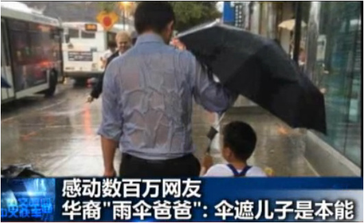 爸爸劉僑為兒子撐傘照片,。(美國中文網(wǎng))