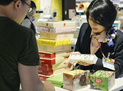 7月3日,成田機(jī)場(chǎng)免稅店內(nèi)一名店員正在應(yīng)對(duì)外國游客購物,。(參考消息援引日本共同社)