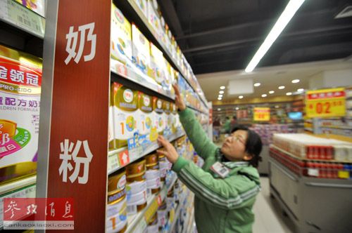 資料圖:在一家超市,,一名工作人員在整理奶粉