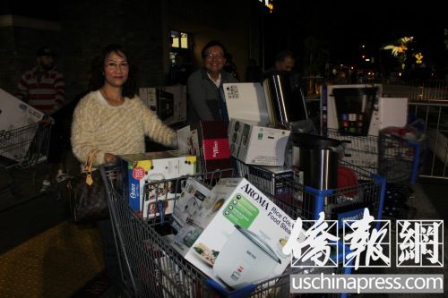徐先生和他的太太推著兩個(gè)購(gòu)物車走出沃爾瑪商場(chǎng),。(美國(guó)《僑報(bào)》/高睿