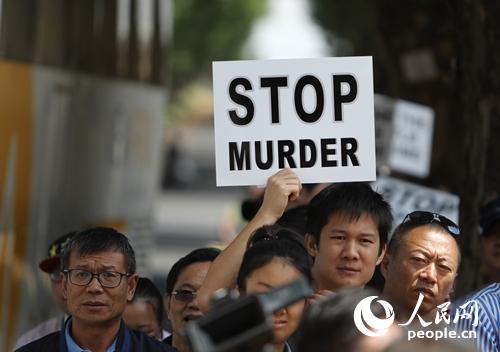 參與游行的華僑華人手舉“停止謀殺”、“停止強奸”等標語,。本網(wǎng)記者