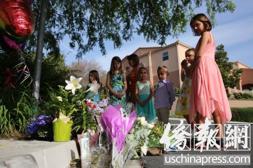 韓偉東5歲女兒艾米麗的同學及朋友在韓宅不遠的街道上為韓家獻花,,寄托哀思,。(美國《僑報》/邱晨