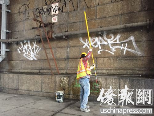 交通局清潔工人在清洗華埠曼哈頓橋下的涂鴉。(林菁/攝)