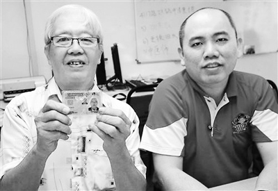 等了50多年才獲得公民身份的林金興(左),,開心地展示馬來西亞公民卡,。來源:中新網(wǎng)