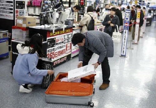 中國游客赴日“爆買”引發(fā)全國人大代表熱議,。圖為中國游客在東京一家商場中購物后裝箱,。(路透社)