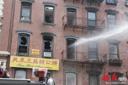消防員向起火公寓室內(nèi)噴水滅火,。