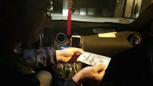 陳先生從非洲裔女顧客手中拿到異常平滑但質(zhì)感粗糙的百元鈔票,,還找了對方65元,。(美國《世界日報》/許雅鈞
