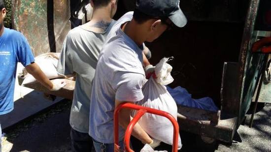 幾名華裔男子快速的將白色袋子搬上卡車離去,。(美國(guó)《世界日?qǐng)?bào)》/黃伊奕