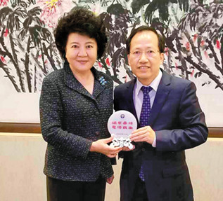 圖為梁冠軍(右)與國(guó)務(wù)院僑辦主任裘援平合影,。