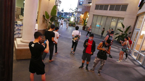 蒙市大西洋時代廣場,,許多華人駐足聚集捕捉小精靈,。(美國《世界日報》)