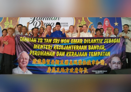 一些丹絨加弄華裔選民高舉布條,,恭賀諾奧馬(左六)重新獲委為部長,;左五者是潘文俊。(馬來西亞《星洲日報》)