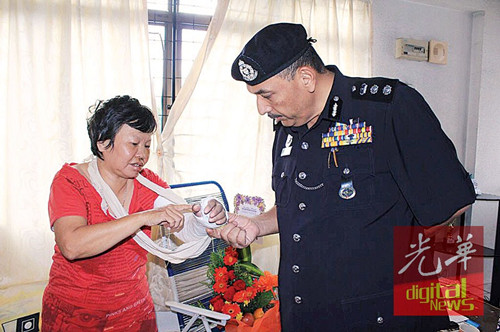 李美珍向米爾解釋骨折的位置。(馬來西亞《光華日報》)