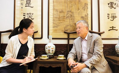 圖為謝明(右)接受本報(bào)記者采訪,。
