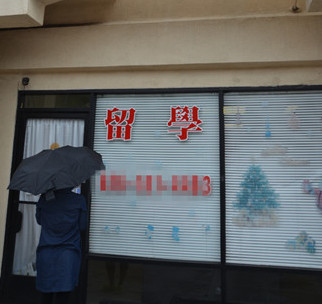 即將面臨遣返的一名女生冒雨到中介門前卻遭閉門羹,。(美國(guó)《世界日?qǐng)?bào)》/高梓原