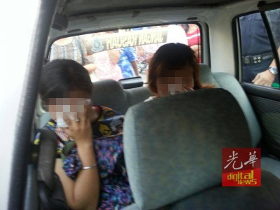 落網(wǎng)的兩名女老千被警員押往警局,,協(xié)助調(diào)查,。(馬來西亞《光華日報(bào)》)