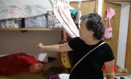 李阿婆指著客廳一角說她每天睡在客廳里與冰箱為伍,。(美國《僑報》/崔國萁