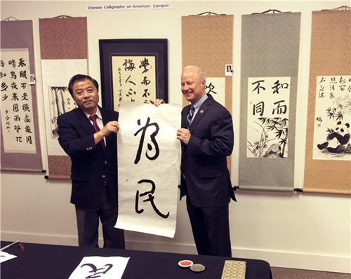 馬克·考夫曼書(shū)寫(xiě)漢字“為民”。(美國(guó)《中美郵報(bào)》)