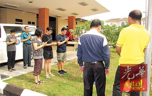 死于心臟病爆發(fā)年邁夫婦的3名子女及親友于醫(yī)院太平間,,持香隨道士念經(jīng)作法。(馬來西亞《光華日報(bào)》)