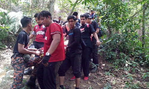 消拯人員在登山客的協(xié)助下將死者遺體抬下山,。(馬來西亞《星洲日報》)