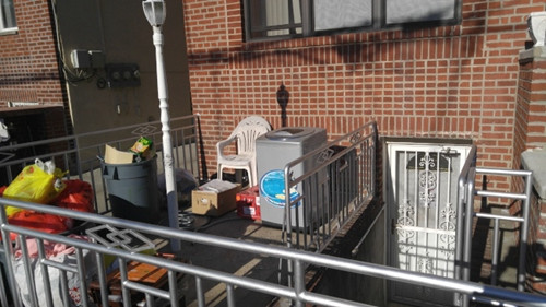 該住宅前院放滿垃圾和廢棄的家具,地庫的門上也被貼查封令。(美國《世界日報》/王靖雯