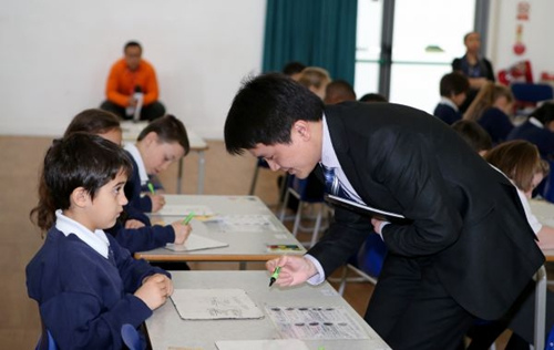 2015年3月17日,來(lái)自中國(guó)上海徐匯區(qū)上海小學(xué)的數(shù)學(xué)老師為英國(guó)倫敦東北部埃塞克斯郡的哈里斯小學(xué)的學(xué)生們上數(shù)學(xué)課,教授“九九乘法表”在數(shù)學(xué)計(jì)算中的運(yùn)用,。