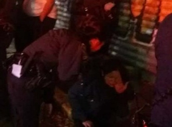 警方在向坐在地上的受害者詢問情況,。(美國《世界日報》/讀者提供)