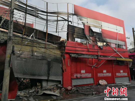 圖為華人商場(chǎng)被焚一空,?!⌒烊?攝