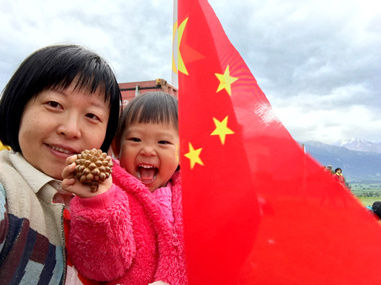 中國僑網(wǎng)于曉瀛抱著女兒等待救援,,女兒手拿中國領(lǐng)事館提供的中國國旗。于曉瀛/攝