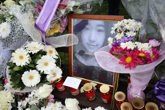 中國僑網(wǎng)11日,羅馬,鮮花與蠟燭圍繞著張瑤的遺照,。(法國《歐洲時報》/張銳 方曼青 攝)