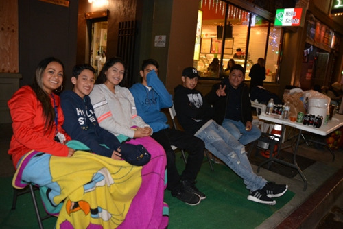 中國僑網(wǎng)少男少女守夜看花車笑得開心,。(美國《世界日報》/丁曙 攝)