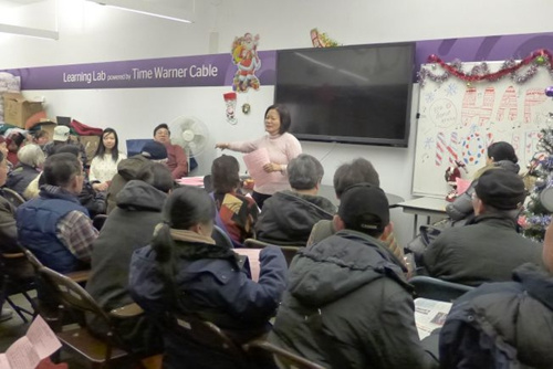 中國僑網(wǎng)廖小姐為民眾介紹糧食券申請規(guī)定,。(美國《世界日報》/高夢梓 攝)