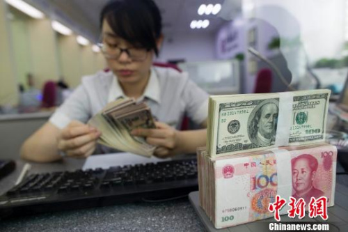 中國僑網(wǎng)資料圖,。山西太原,銀行工作人員正在清點貨幣,。 張云 攝
