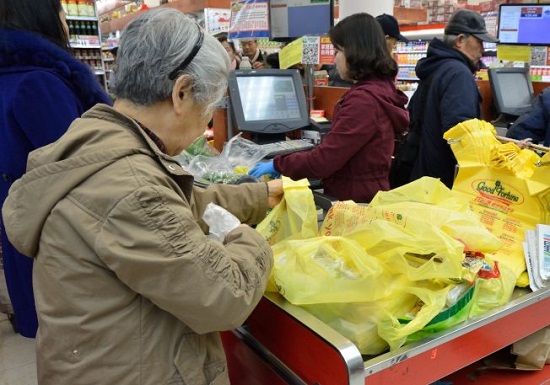 中國僑網(wǎng)塑料袋收費法案倒數(shù)一個月,,民眾開始“囤積”,,買幾把菜就拿五、六個塑料袋,。(美國《世界日報》/朱澤人 攝)