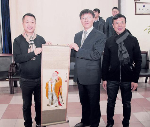 中國(guó)僑網(wǎng)張宏明(前排左2)向法國(guó)華僑華人會(huì)贈(zèng)送孔子繡像,。(法國(guó)《歐洲時(shí)報(bào)》/黃冠杰 攝)