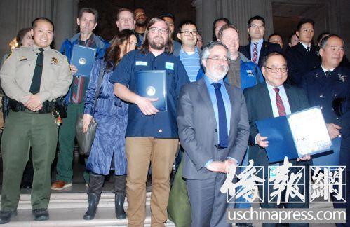 中國(guó)僑網(wǎng)市議員佩斯金和受表彰的救火英雄合影,。(美國(guó)《僑報(bào)》/吳卓明 攝)