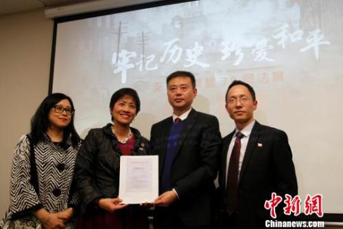 中國僑網(wǎng)圖為黃素梅(左二)接收南京大屠殺遇難同胞紀念館商請收藏在加拿大安大略省推動設(shè)立“南京大屠殺紀念日”的提案草案的函件,?!∮嗳鸲z