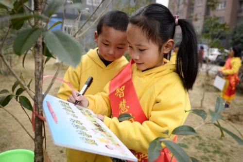 中國僑網 2017年3月10日,合肥市大興鎮(zhèn)新海家園小區(qū),小朋友在樹苗認養(yǎng)牌上寫上了自己的名字,。(新華社照片)