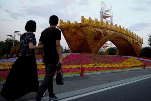 中國僑網(wǎng)5月10日,,行人走過北京國家會議中心門前的“絲路金橋”景觀作品。該會議中心為“一帶一路”國際合作高峰論壇舉辦地之一,。(路透社)