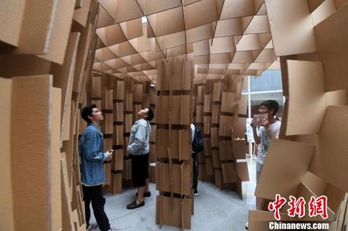中國僑網(wǎng)5月13日,,學(xué)生們在體驗參加比賽選手搭建的“房屋”,?!埍蟆z