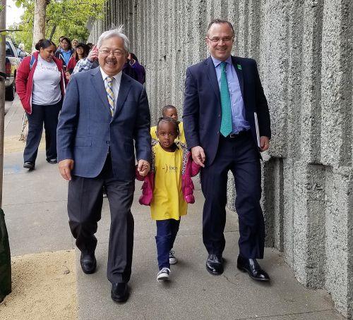 中國僑網(wǎng)舊金山市長李孟賢(左)和公共土地信托城市公園主任貝納普(右),,帶著一名兒童步行前往山頂公園,。(美國《僑報》/市長李孟賢辦公室提供)