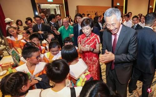 中國僑網(wǎng)李顯龍和文化,、社區(qū)及青年部長傅海燕與參加開幕演出的小演員們親切交談。(新加坡《聯(lián)合早報》/梁偉康 攝)
