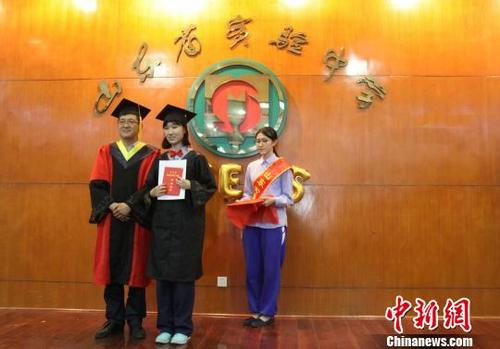 中國僑網(wǎng)山東省實驗中學(xué)副校長林寶磊為中美高中課程班畢業(yè)生頒發(fā)畢業(yè)證書和精美紀(jì)念冊,?!≮w曉 攝