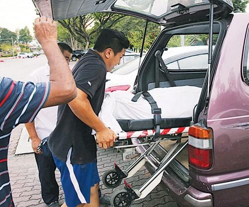 中國僑網(wǎng)死者的遺體被抬上車準備送往醫(yī)院太平間,。(馬來西亞《光華日報》)